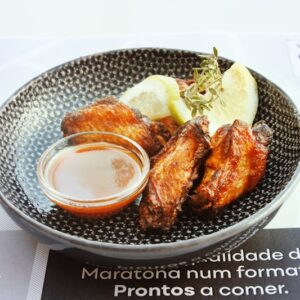 a plate of food that includes chicken wings and a dipping sauce